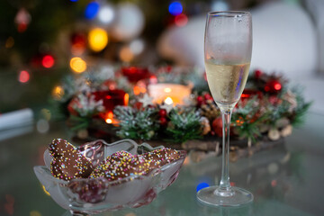 A glass of champagne and cookies on the background of the Christmas tree