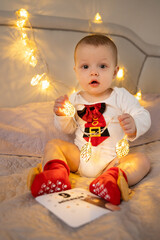 cute boy holding a christmas garland in his hands