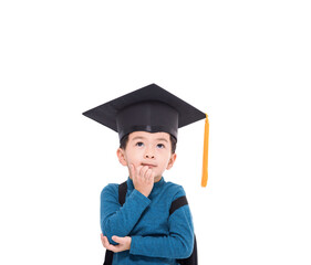 Happy little boy student in a graduate cap thinking and looking up