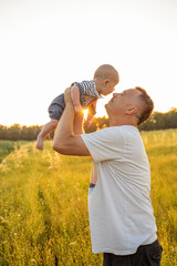 Father holding with great love the child in his arms at sunset