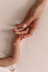 Close up of hand of mother holding hand of little newborn baby