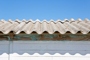Old aged dangerous roof made of corrugated asbestos panels - one of the most dangerous materials in buildings and construction industry so-called hidden killer