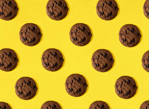 Top view of chocolate cookies on the yellow background. Flat lay. Pattern.
