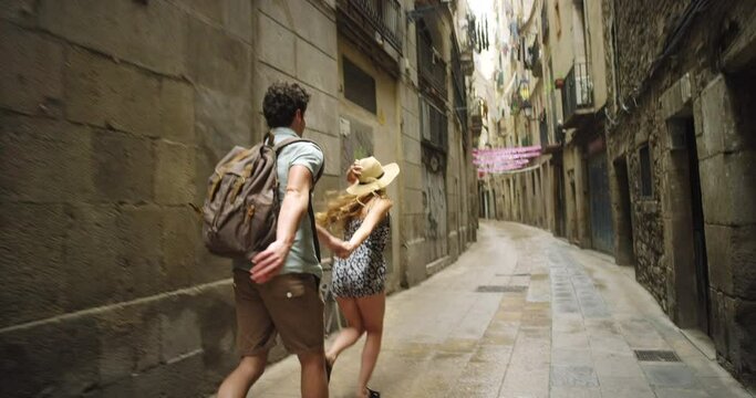 Couple, running and adventure in travel holiday, adventure and backpack in Barcelona, Europe or happy smile together. Young man, woman or run in town, vacation and city with freedom, love and explore