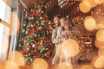 Candid authentic happy married couple spending time together at wooden lodge Xmas decorated
