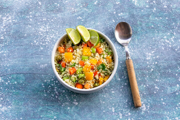 Healthy food cauliflower fried rice has vegetable in white bowl on blue wood table.