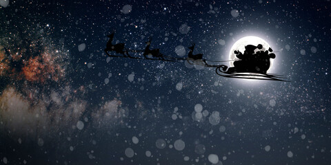 Fototapeta premium Santa Claus flies on Christmas Eve in the night sky with snow