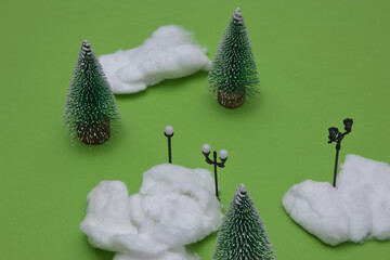 Winter idyll with pine trees, snow, street lights on a green background. Minimal winter conception.