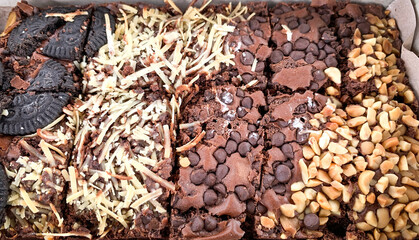 close up of chocolate baked brownies with various toppings.