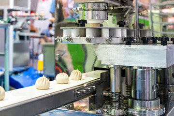 loaf dough chinese or asian food (steamed stuffed buns) on belt conveyor after forming or manufacturing by automatic food making machine in industry