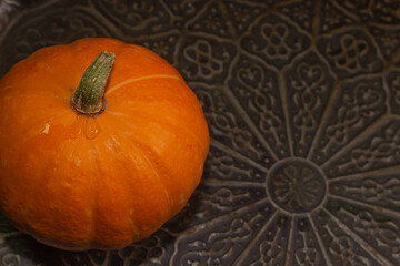 Yellow-orange pumpkins on a black background the concept of Halloween and the autumn harvest of pumpkin close-up copyspace from above