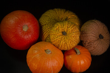 Yellow-orange pumpkins on a black background the concept of Halloween and the autumn harvest of pumpkin close-up copyspace from above