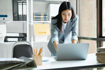 Young asian businesswoman working at office using laptop.