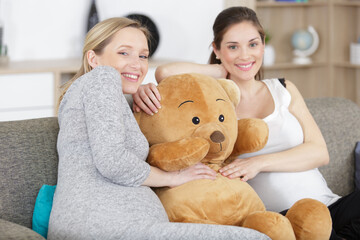 female friends holding a teddy bear