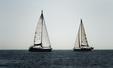 Fototapeta na wymiar Two sailing ships crossing in the ocean against white sky