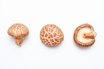 Shiitake mushrooms on white background close-up, top view.