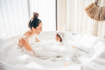 Mother and child having bubble bath.