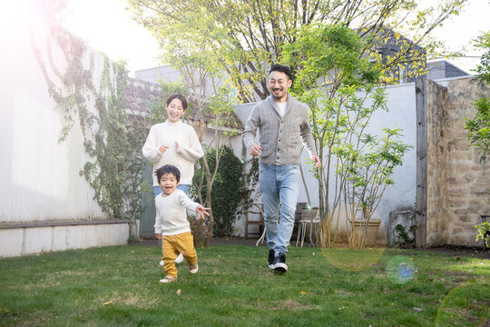 メインビジュアルにも！庭や公園で走り回る子どもと家族のイメージ