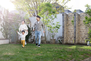 庭や公園で走り回る子どもと家族のイメージ 右にコピースぺースあり