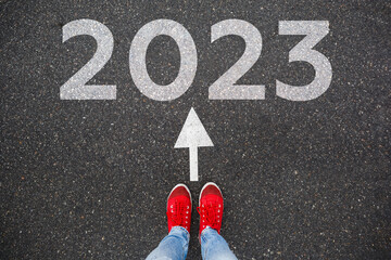 Obraz na płótnie Canvas Red sneakers on the asphalt road with passing 2021 to 2022. Concept for success in the future goal and passing time. Happy new year concept