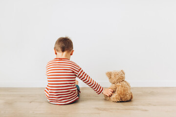 Portrait of little boy playing with his friend teddy bear toy