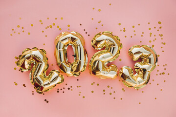 Happy New Year 2023 greeting card. 2023 golden foil balloons numbers and confetti. Top horizontal...