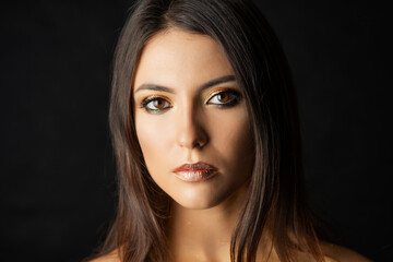 Obraz premium Close-up portrait of young woman with golden makeup.