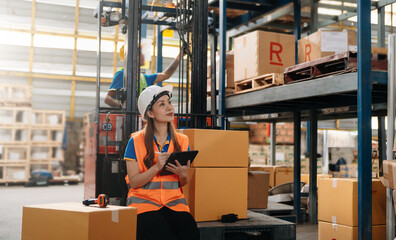 Management having discussion at warehouse with white hardhat using digital tablet Working in...