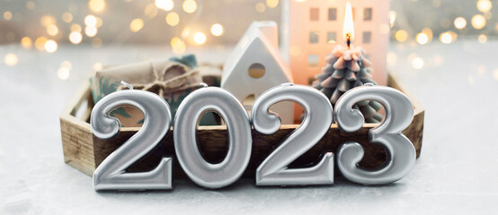 Christmas and New Year card. Number 2023 on holiday background. Christmas lights bokeh background....
