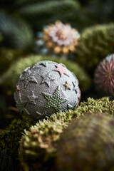 Obraz na płótnie Canvas Decorative christmas ball with stars on a green moss background