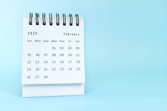 Selective focus of February 2023 desk calendar on blue background with copy space.