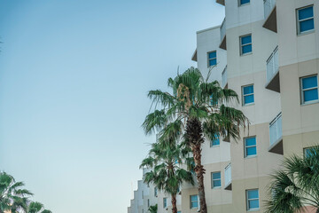Fototapeta na wymiar Multi-storey apartment ith triangular balconies in a row with a view of palm trees at Destin, FL