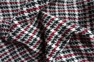 Draped thick black, red and white woolen twill fabric