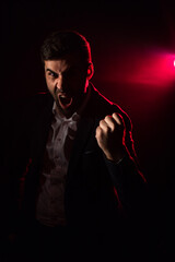 Photo of emotional man in the suit on pink background.