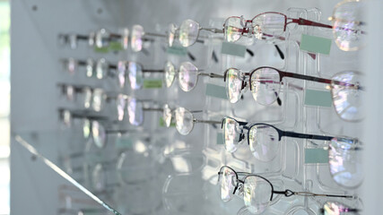 Fashionable corrective eye glasses on a shelf in optical store. Optics, health care and vision concept