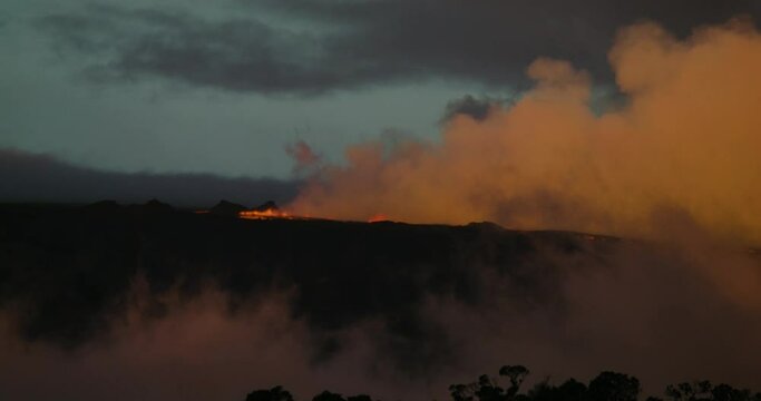 Mauna Loa erupting on Hawaii Island on November, 28th 2022.Volcano erupting viewed from Saddle Road.  Volcano cloud at daybreak with lava.  Zoom shot with Red camera