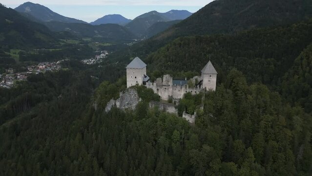 Slow flight around Medieval Castle on a hill. Old Castle remains in Austria, Burgruine Gallenstein. Historic fortress ruins with two towers, on a mountain, captured by drone in 4k, 24fps.