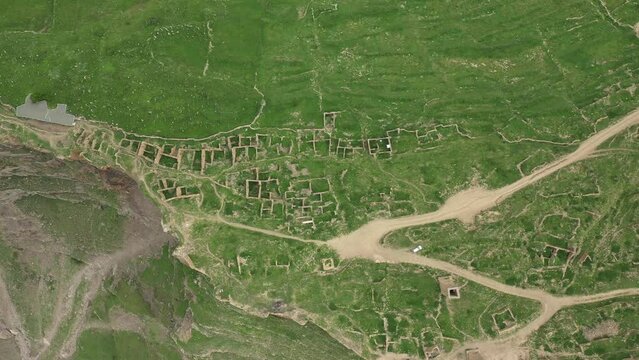 Above view of abandoned Goor village with ancient ruins of former houses. Drone view of beautiful Dagestan mountains