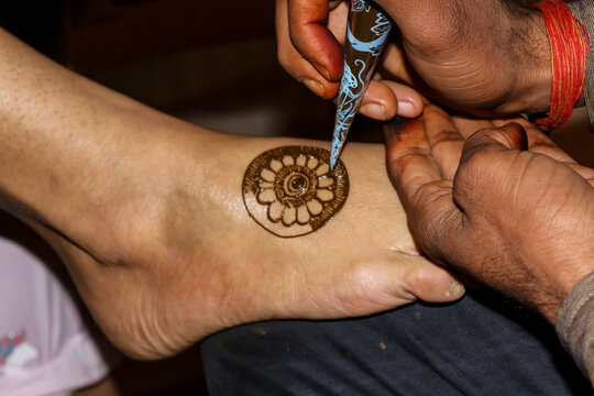 Mehandi appying Indian traditional wedding rituals design art tattoo closeup hands feet
