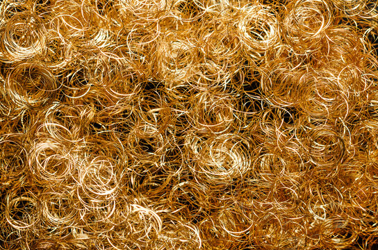Golden metallic angel hair, background, from above. Curly gold lametta angel hair, made from very thin plated copper wire. Special decoration, used to decorate Christmas trees and Christmas wreaths.