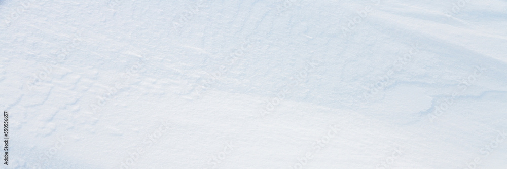 Wall mural beautiful winter background with snowy ground. natural snow texture. wind sculpted patterns on snow 