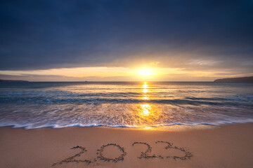 Happy New Year 2023 sea sunrise on the beach shore concept