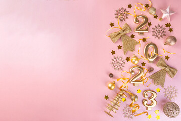 New year 2023 celebration greeting card background Gold numbers 2023 with golden party decoration, stars confetti on pink background. Flat lay, Merry Christmas, Noel happy New Year holidays banner