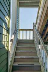 Navarre, Florida- Narrow staircase near the wall with painted wood lap sidings
