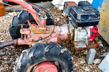 A small walk-behind tractor for plowing a garden is in the garage.