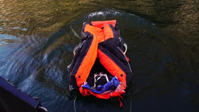 Davit launched life raft inflating on a calm lake