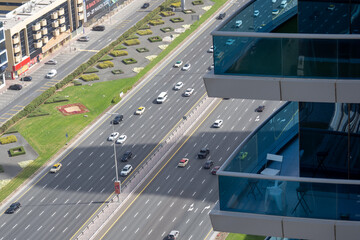 Stone jungle, view from a skyscraper on a multi-lane highway in the center of Dubai. Glass balconies of skyscrapers.