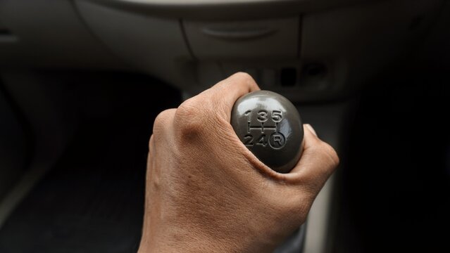 close up the hand holding the car gear stick. Part of vehicle 