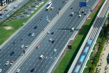 Complicated traffic management in the center of Dubai. Multi-lane highway and subway train...
