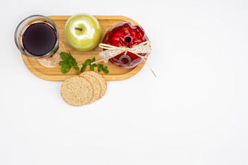 White background with apple, pomegranate, glass of wine and bread tortillas on wooden tray as Rosh Hashanah concept. Pomegranate, Nar Bayramı New Harvest Festival